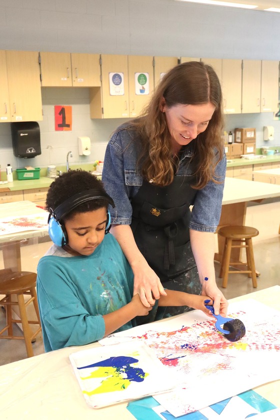 A student and a teacher painting a picture