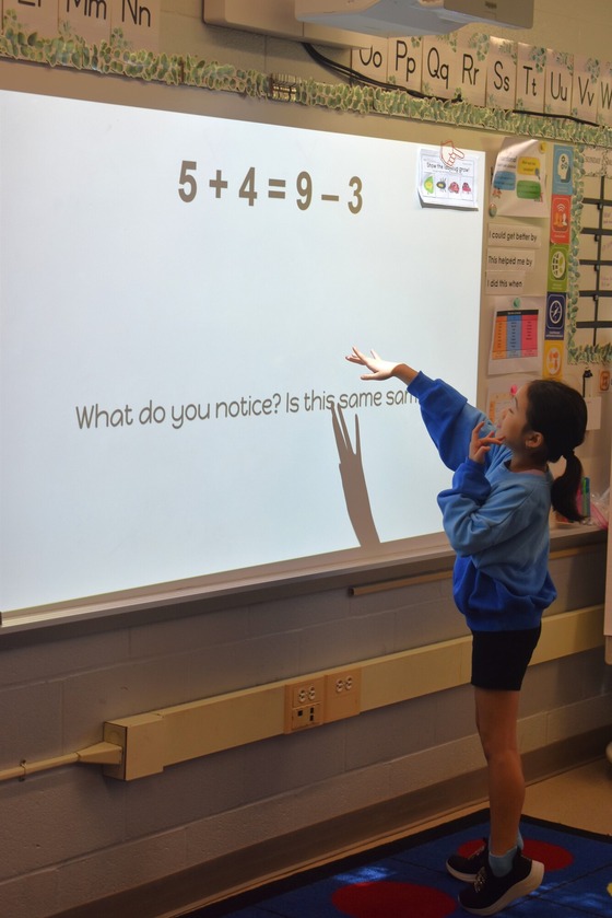 A student at the smart board solving a math problem