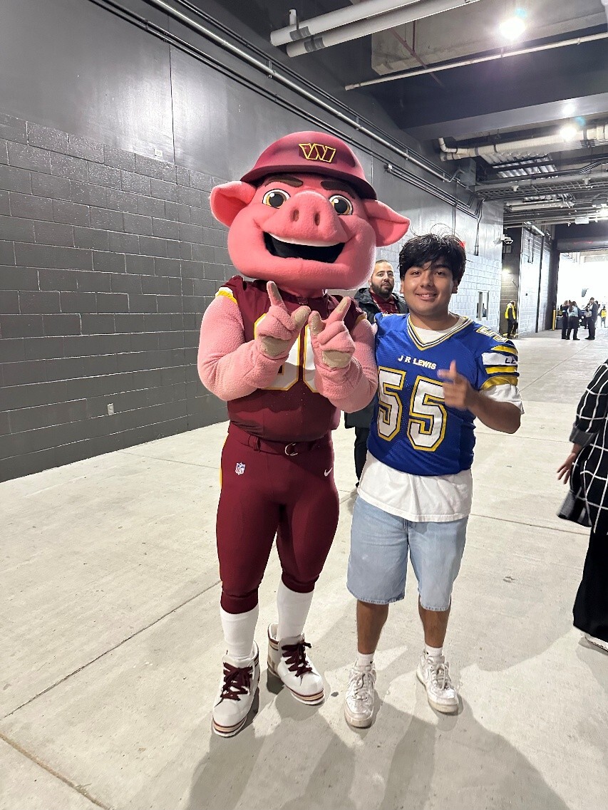 Student in a blue jersey with the number 55 with the Washington football team mascot