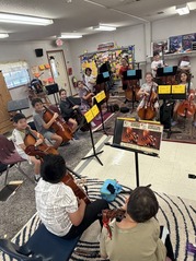 students sitting and holding various strings instruments