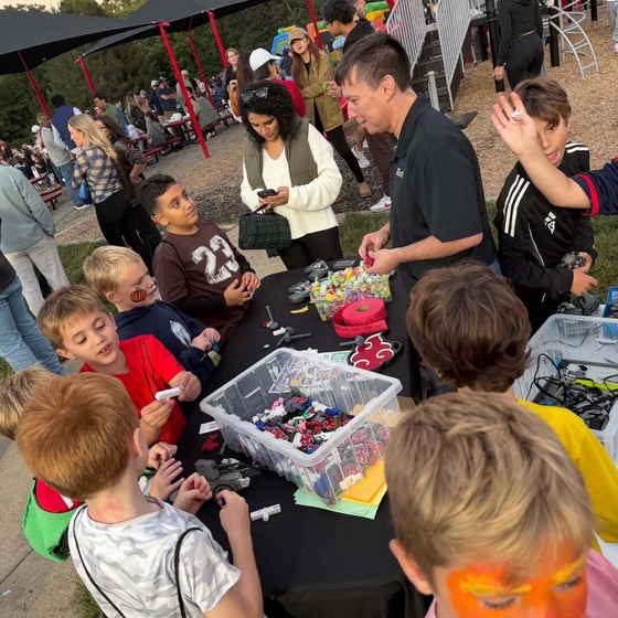 Children standing around a prize table at an outdoor carnival