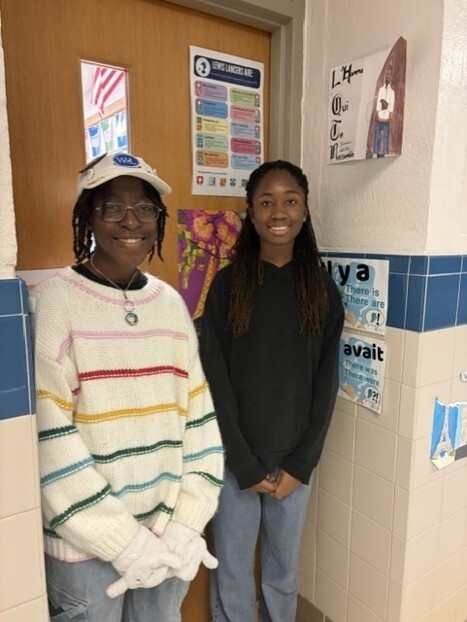 Image two students standing outside of a classroom