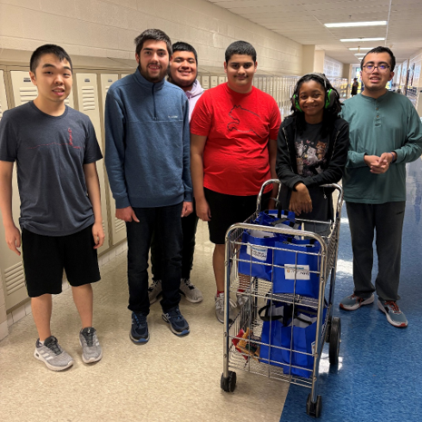 a group of students with a shopping cart of gift bags