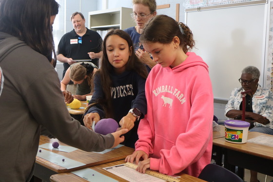 2 girls presenting their work during the 6th grade parent invite