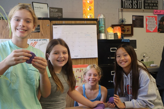 4 girls presenting their work during the 6th grade parent invite