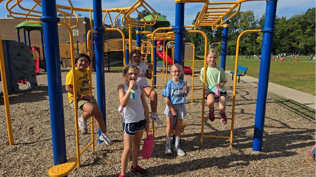 5 girls sitting on the playground equipment