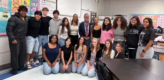 Dr. Reid smiling for a picture with students
