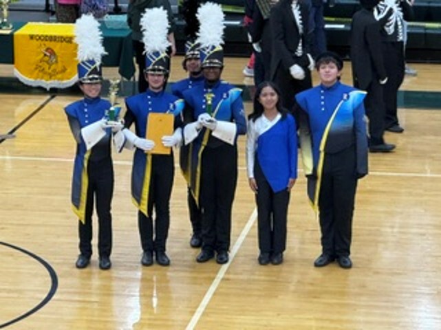 Students in blue gold and black band uniforms on the basketball court