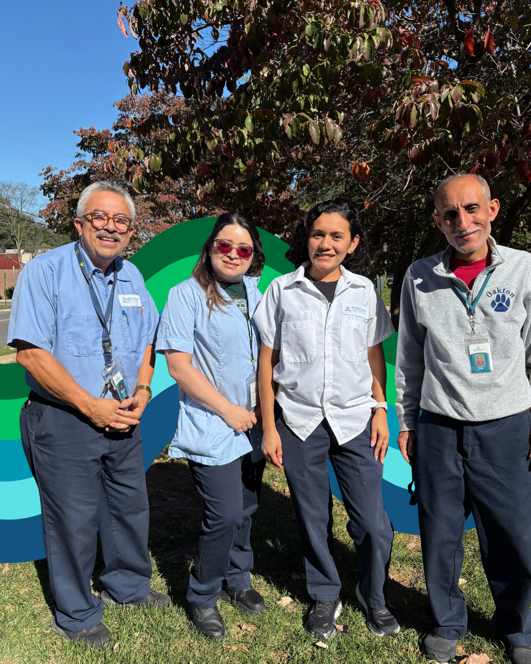 Four smiling Fairfax County Public Schools custodians stand outdoors in front of a tree and a green and blue graphic backdrop