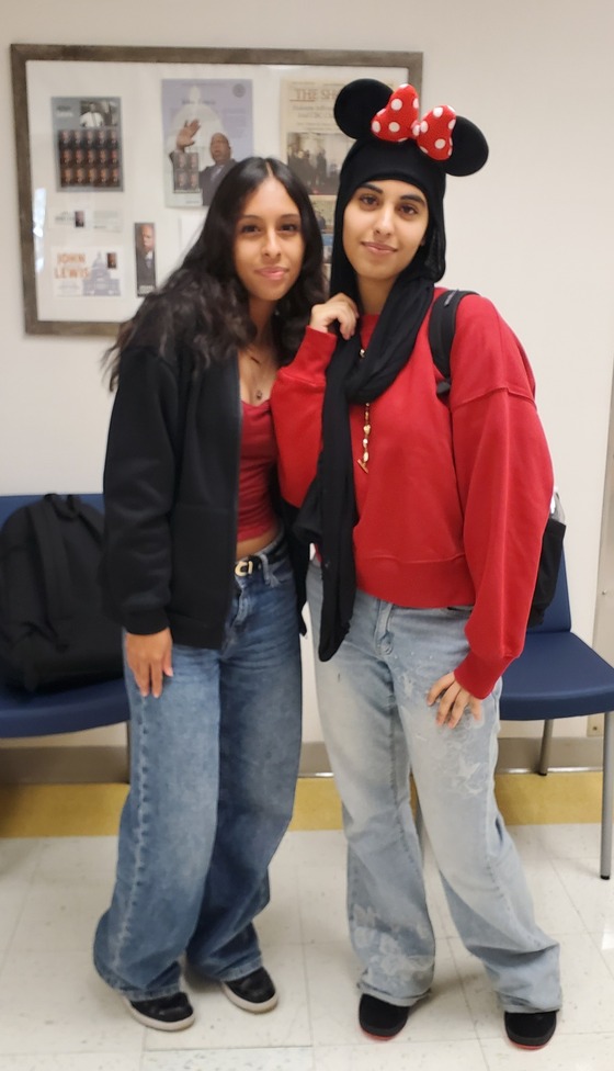 Image of two students dressed for spirit week. One in a red sweater with mickey mouse ears.