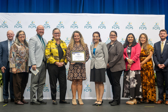 Ms. Martins posing with her FCPS Impact award with Dr. Reid, Region 4 leadership, and members of the School Board.