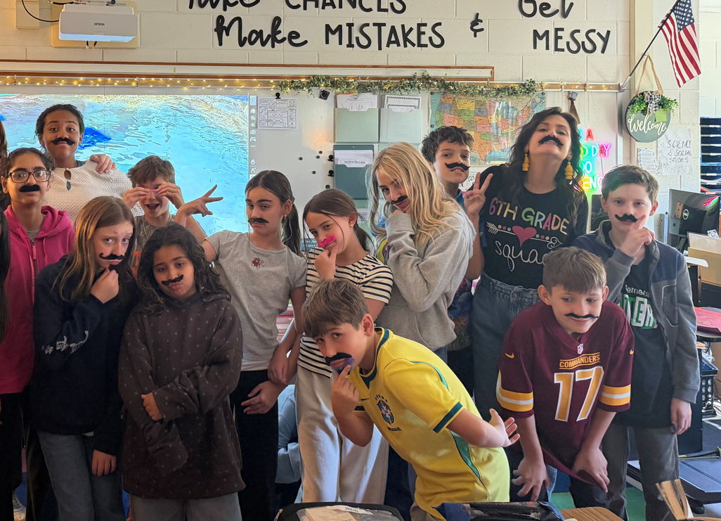 Photo of 6th grader in science class wearing adhesive mustaches