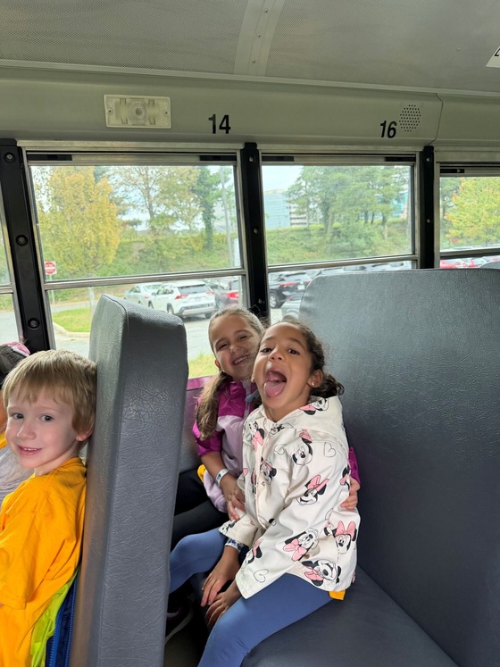 A picture of 3 students on the bus heading to Cox Farm