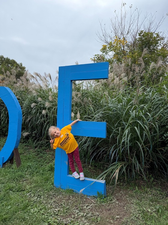 A student playing on a giant capital E at Cox Farm
