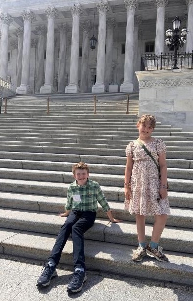 Oak View Elementary students Adaleigh and Noah smiling while posing on the grand stone steps of the U.S. Capitol building.