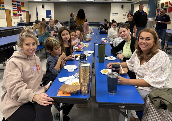 5th and 6th Grade families enjoying a potluck breakfast in the cafeteria