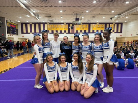 School cheerleaders posing for a photo in a gym