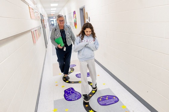 Dr. Reid walks with student down the hallway at school