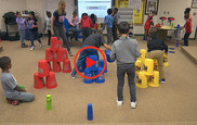Students stacking cups in classroom