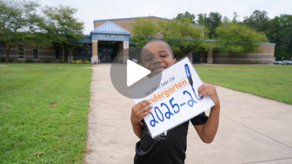 Student holding up first day of school sign