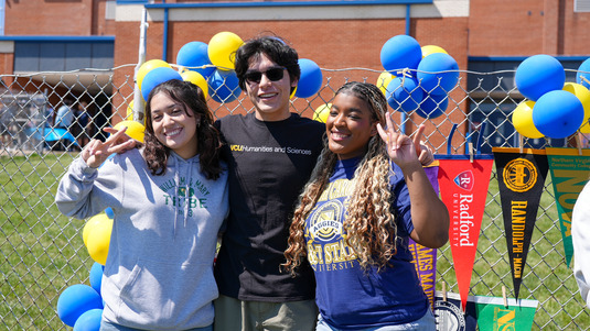 three students wearing college gear