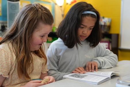 two elementary school girls reading