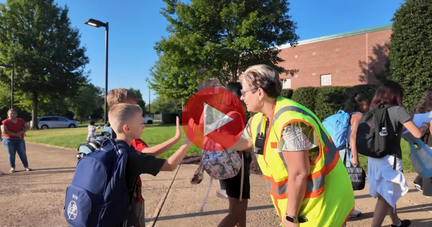 teacher high fiving two students