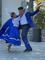 A couple dancing in colorful blue and white costumes