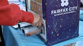 detail photo of a person's hand depositing quarters in a mini-art vending machine
