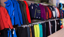 Image of winter coats and pant on a clothing rack in a store