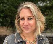 Image of author Rachel Louise Snyder. She has short blond hair and is wearing a denim jacket with a white top underneath 