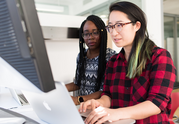 two woman looking on the computer
