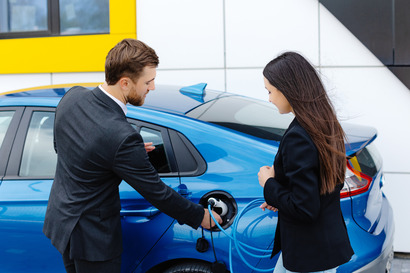 car salesman showing an interested buyer an electric vehicle