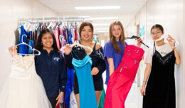 Image of four girls each holding up their own prom dress