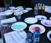 Image of a table with glitter in bottles to decorate paper plates