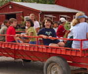 Kids riding in the back of a red wagon