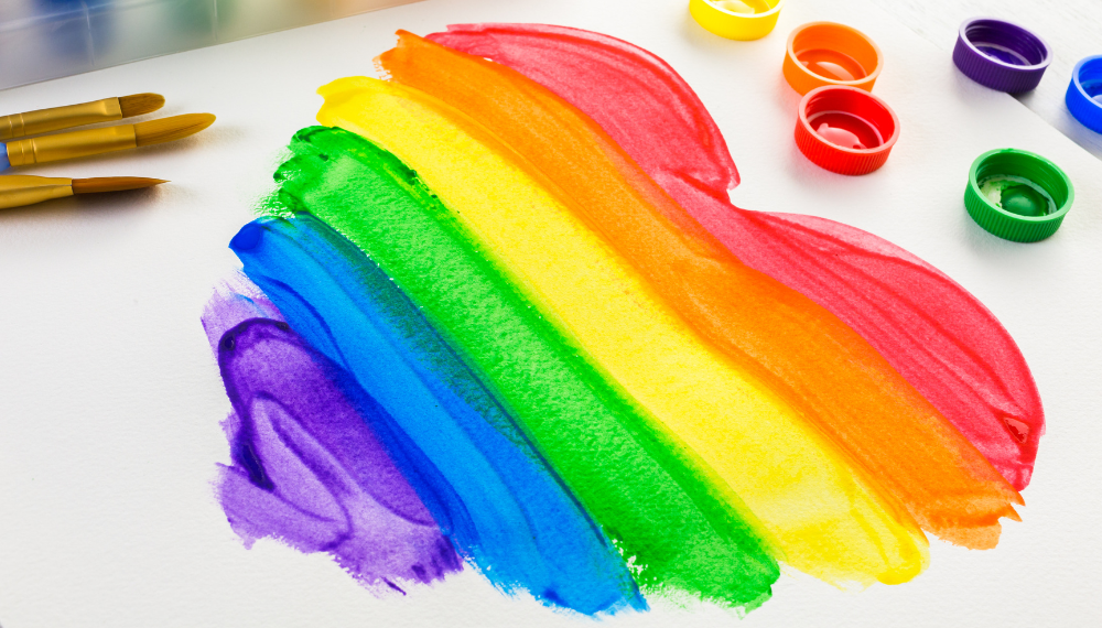 Image of a painted Pride flag in the shape of a heart