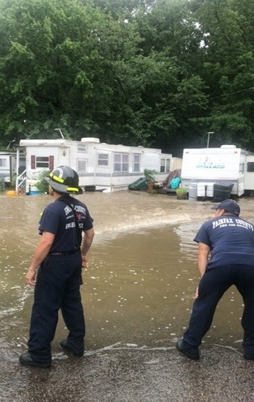 two emergency workers looking at flooding in a mobile home community
