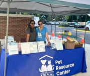 Image of Animal Shelter employees under a blue tent and table at the Volunteer Fair
