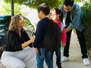 parents and kids with backpacks outside