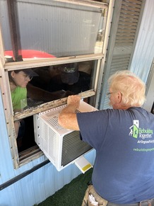 people installing a AC window unit