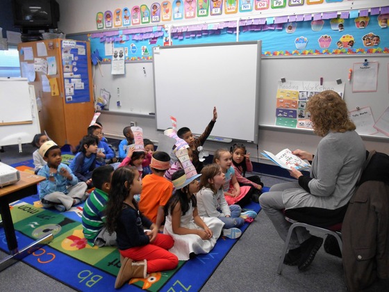 Teacher in a classroom reading a book to her students