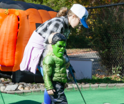 Image of children dressed in Halloween costumes playing mini golf.