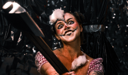 Image of a girl dressed as a scary teddy bear with stitches drawn onto her face