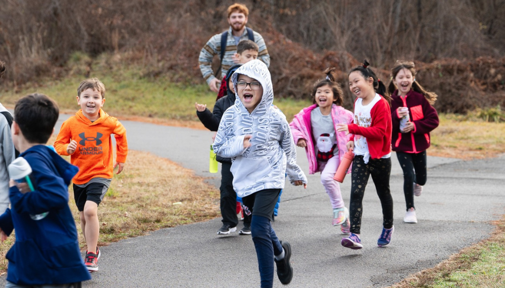 Image of kids running outdoors in fall clothing.