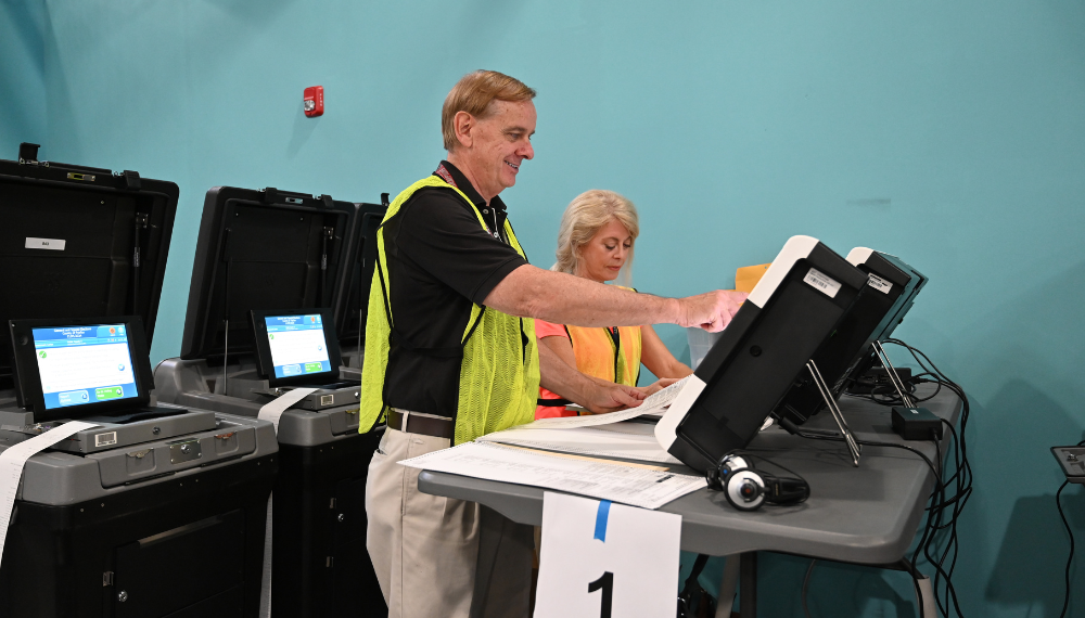 Image of election officers operating a ballot scanner.