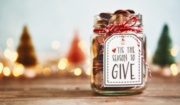 Image of a jar filled with coins and a tag on the jar reads "Tis the season to give."