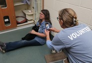 Volunteer Taking Photo of Volunteer on ground with cat