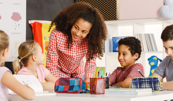 woman speaking with children in a classroom