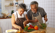 Two older adults cooking 